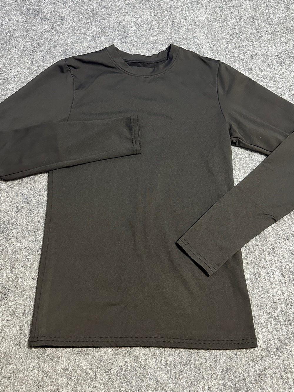 Kids dark black long-sleeve athletic crewneck shirt made from a smooth cloth.